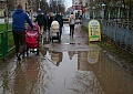 Тротуары, после дождя залиты огромными лужами.